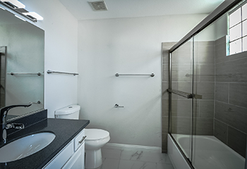 Modern master bathroom remodel in Burbank with new tile installation and glass shower enclosure.